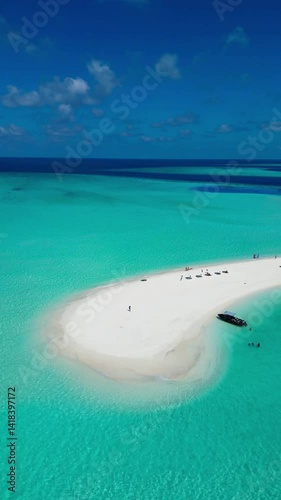 Stunning drone view showing people enjoying the sun-kissed sandbank in the Maldives