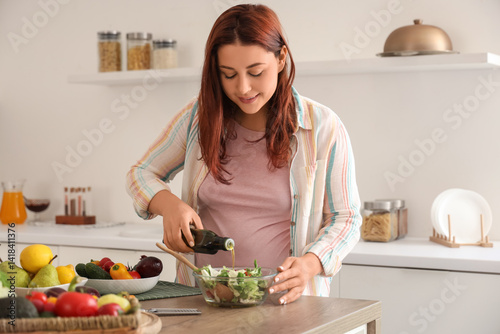 Young pregnant woman adding...
