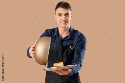 Young male waiter holding t...