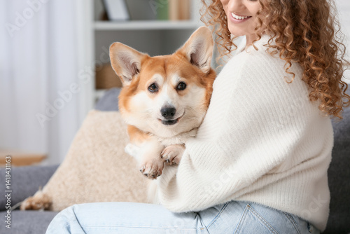 Young woman sitting on sofa...