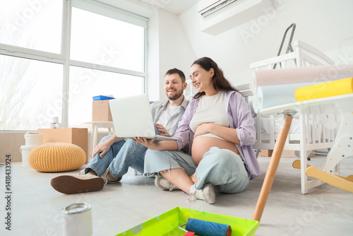 Young pregnant couple using...