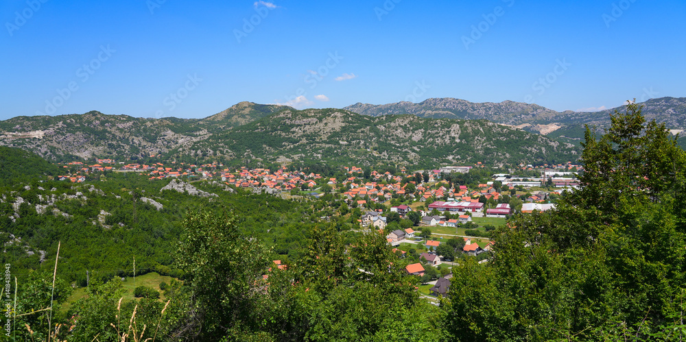 Aerial view of Cetinje, the former capital of Montenegro in the Balkans - Houses in a lush valley surrounded by the mountains of Eastern Europe