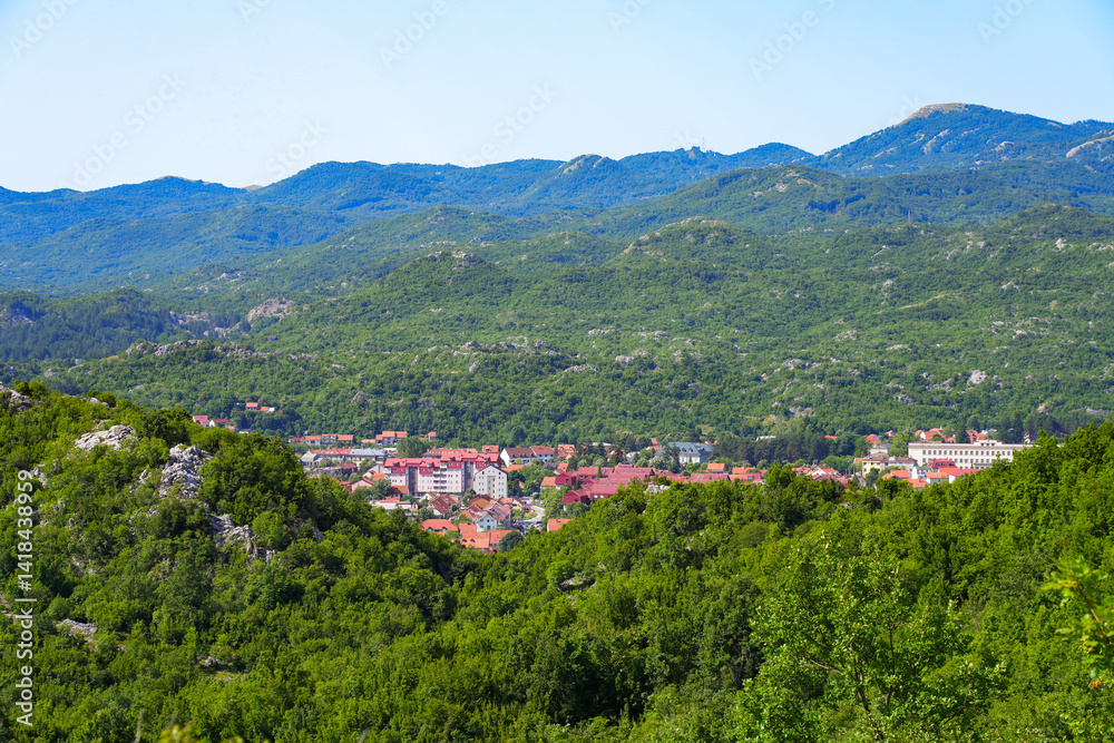 Aerial view of Cetinje, the former capital of Montenegro in the Balkans - Houses in a lush valley surrounded by the mountains of Eastern Europe