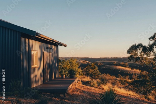 A contemporary cabin perched on a hillside at sunset, offering breathtaking panoramic views of the rolling landscape and lush trees in the background
