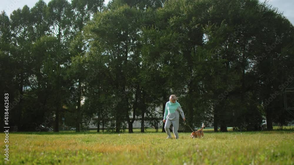 Wide view of trainer running with dog in lush green natural park during bright summer day, surrounded by tall trees, open grassy field, relaxed joyful outdoor atmosphere perfect for pet exercise Wide view of trainer running with dog in lush green natural park during bright summer day, surrounded by tall trees, open grassy field, relaxed joyful outdoor atmosphere perfect for pet exercise