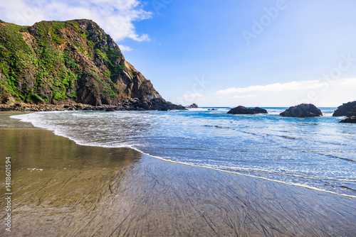 Photos Breathtaking view of Pfeiffer Beach in Big Sur, California, featuring its iconic rock arch, golden sand, and turquoise waves