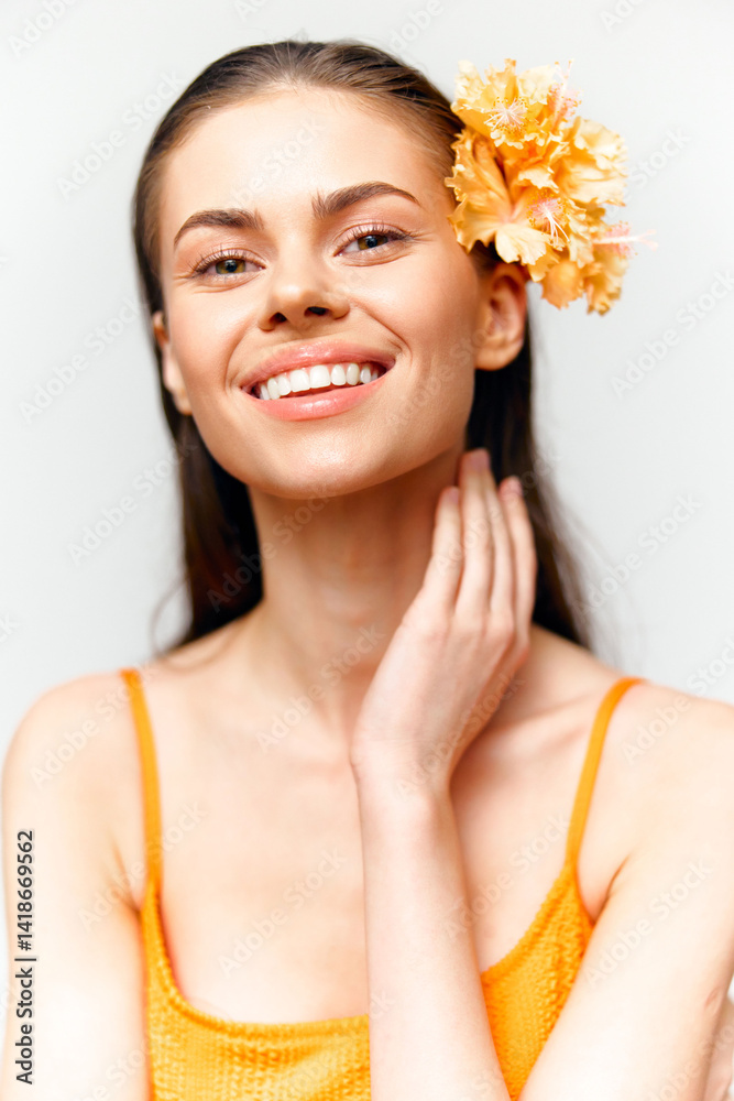 Young woman with a cheerful smile and a flower in her hair, wearing a bright orange top, radiating positivity and summer vibes. Young woman with a cheerful smile and a flower in her hair, wearing a bright orange top, radiating positivity and summer vibes.