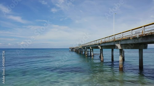 Wallpaper Mural Long concrete pier stretches over tranquil turquoise ocean under bright sunny sky with few clouds, calm water surrounds pillars. Torontodigital.ca