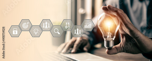 Hand chooses light bulb or lamp icons with business growth icons for human resources or leadership and creativity thinking idea motivation or vision and knowledge learning.