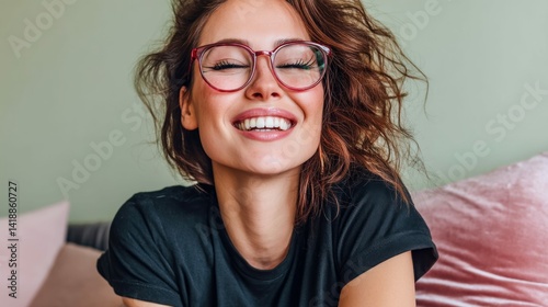 Obraz na płótnie A happy woman with red glasses closes her eyes while smiling broadly, showcasing her white teeth and carefree spirit, enjoying a moment. w salonie