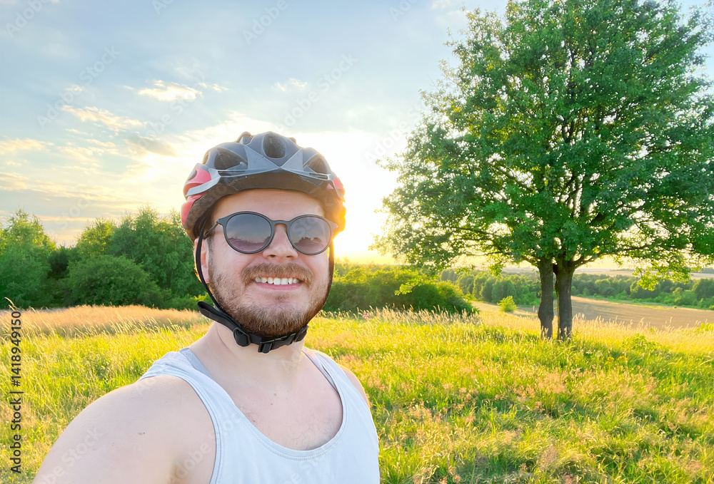 Smiling Cyclist Takes Selfie in Sunny Outdoor Field