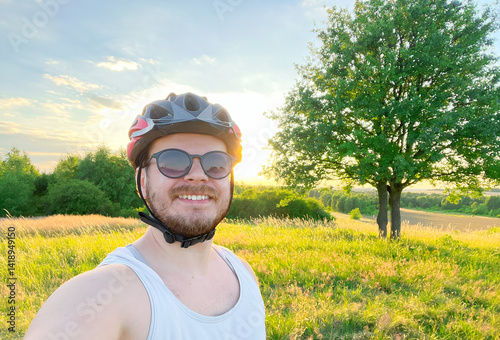 Smiling Cyclist Takes Selfie in Sunny Outdoor Field