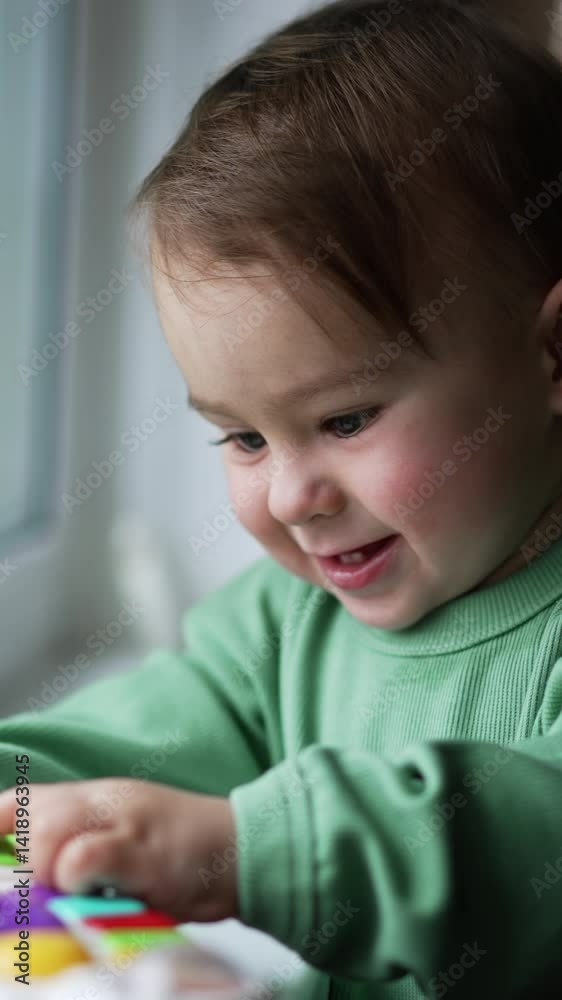 Small cute child playing with toys. Young infant baby having fun at home. Vertical video Small cute child playing with toys. Young infant baby having fun at home. Vertical video