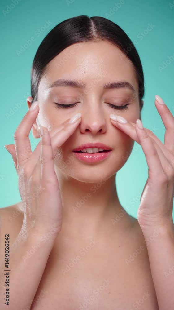 Beautiful Young Woman Touches Her Perfect Face. Natural Cosmetic Skincare Products. Woman demonstrate moisturizing facial care. Elevating Close-up Portrait with Isolated Background. Vertical video Beautiful Young Woman Touches Her Perfect Face. Natural Cosmetic Skincare Products. Woman demonstrate moisturizing facial care. Elevating Close-up Portrait with Isolated Background. Vertical video