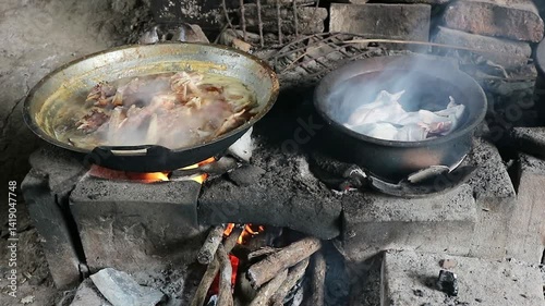 The process of roasting whole chicken meat by roasting it on a wood stove in a traditional and simple way, the meat is skewered with bamboo so that it roasts evenly.
