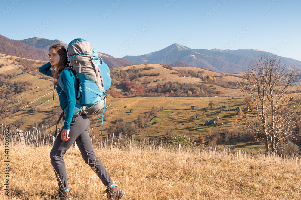 Naklejka premium Travel concept and background. Defocused tourist with backpacking on foreground and panoramic alpine scenery.