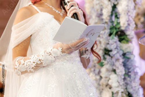 Εκτύπωση καμβά The bride reading her vows into a microphone at the wedding ceremony