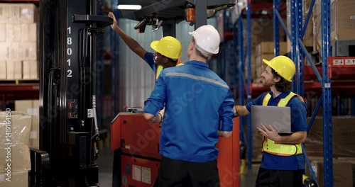 Wallpaper Mural African adult male forklift operator gives thumbs up while communicating with two colleagues holding laptop and documents during active coordination process in warehouse environment filled with boxes Torontodigital.ca