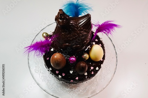 Chocolate Easter Cake Decorated with Colorful Eggs and a Hen Figure on Top.
