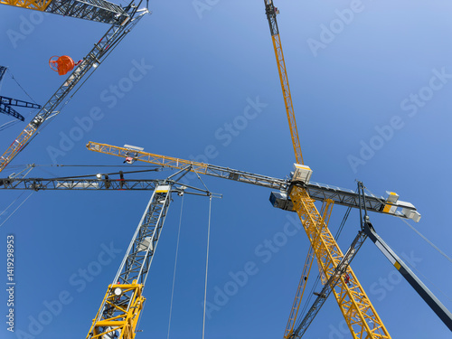 Construction cranes. View from below. Crane used to construct palaces, houses or buildings. Construction site. General contest