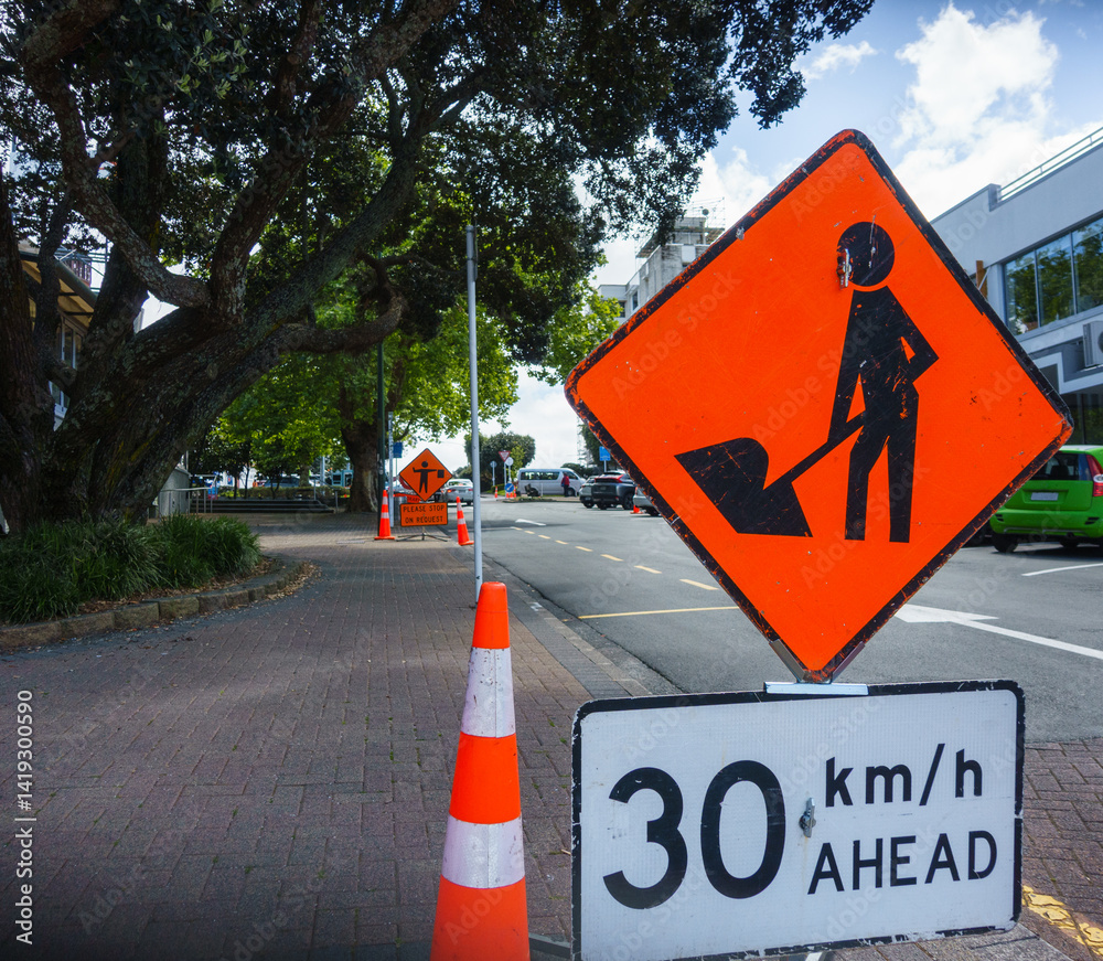 Roadwork Ahead and Please Stop on Request road signs by the road. Roadworks in Auckland.