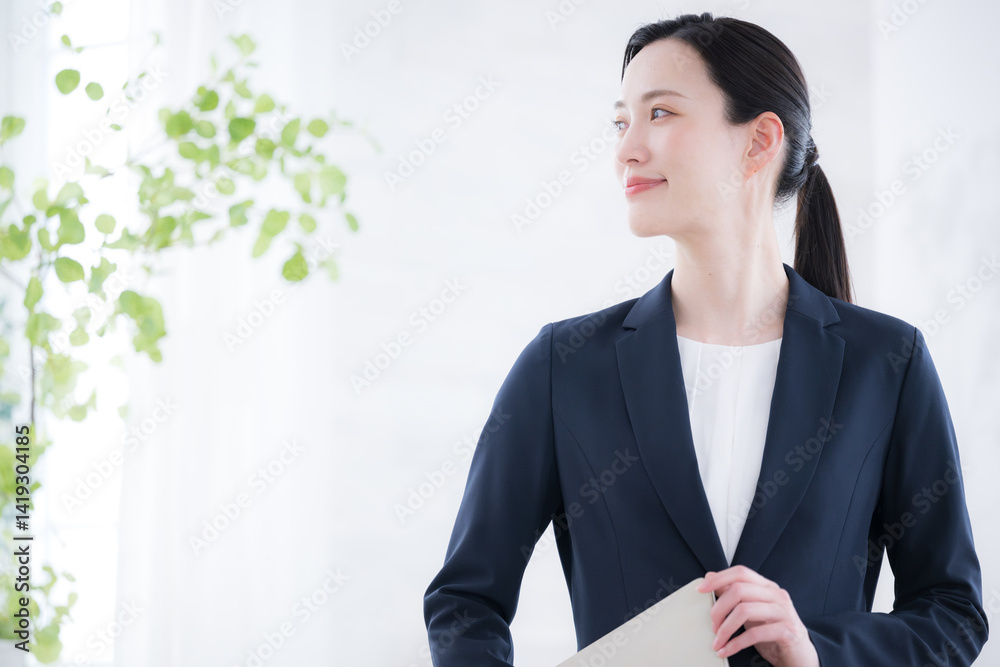Close-up looking back at the profile of a business image of a sales woman or a beautiful consultant in a backlit green window Close-up looking back at the profile of a business image of a sales woman or a beautiful consultant in a backlit green window