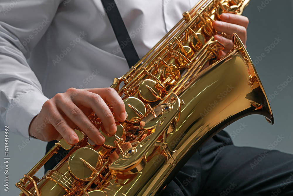 Fototapeta premium Professional musician playing saxophone on grey background, closeup
