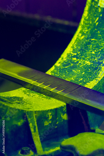 Quality Control Test Block for Magnetic Particle Inspection. Fluorescent green MPI reference standard with defects under ultraviolet illumination
