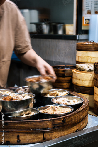 Chef preparing traditional dim sum in bamboo steamer baskets in hong kong