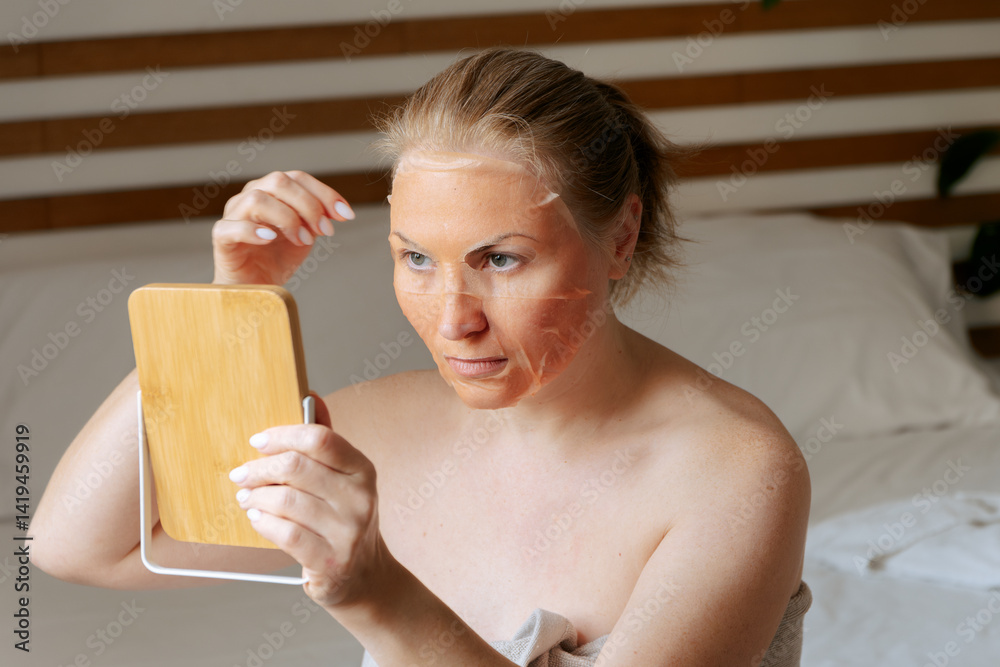 A woman applies a lifting mask with peptides to her face facial skin care rejuvenation A woman applies a lifting mask with peptides to her face facial skin care rejuvenation