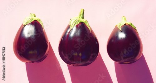 Three Eggplants Fresh Closeup Minimal Pink Background