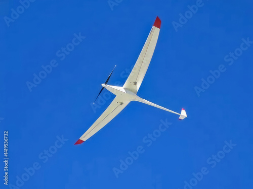 Obraz na płótnie A white and red plane is flying in the sky. The plane is very large and has a red tail. The sky is clear and blue, and the plane is the only object in the sky w salonie