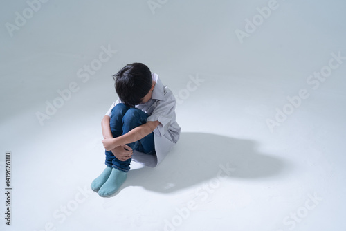 Sad boy sitting alone with head down
