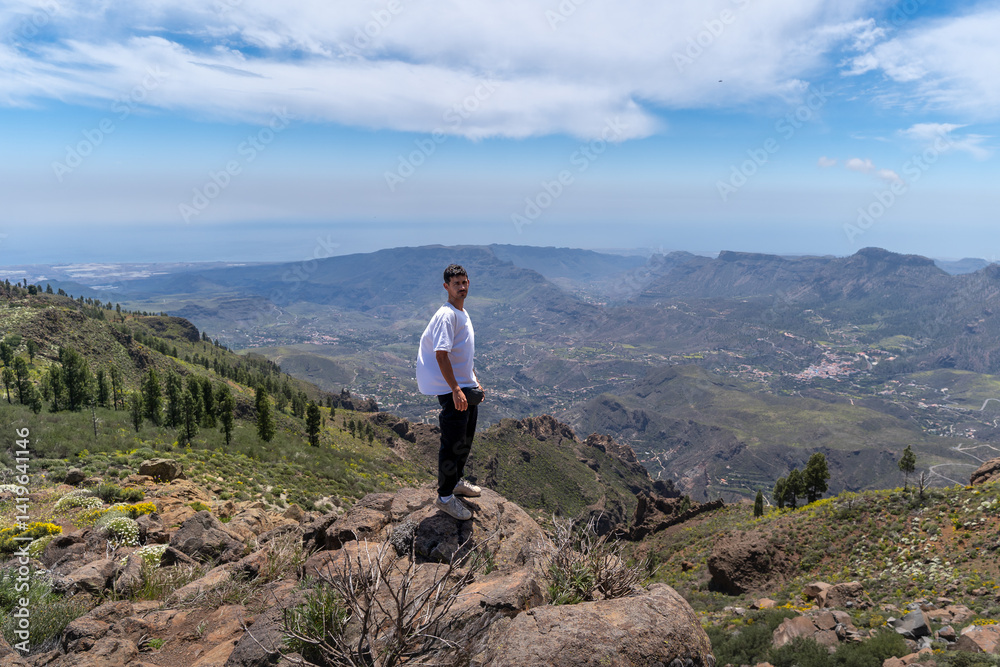Obraz premium Young man hiking at the top of Gran Canaria Island in a sunny day. Canary islands. Spain