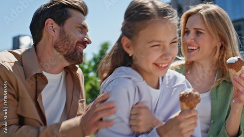 Overjoyed relatives holding ice-cream in summer picnic on green lawn closeup