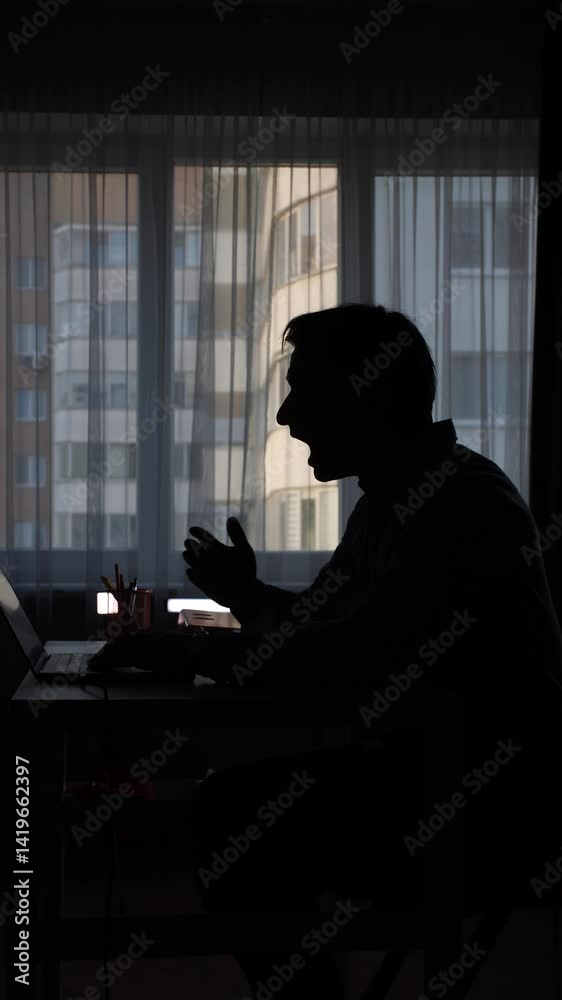 vertical video Tired man yawning and working at laptop in dark room vertical video Tired man yawning and working at laptop in dark room
