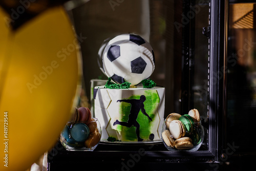 Delicious two-tiered birthday cake decorated in football style.