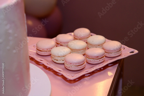 Obraz na płótnie Delicate pink macarons with a creamy filling, arranged on a white cake stand. w salonie