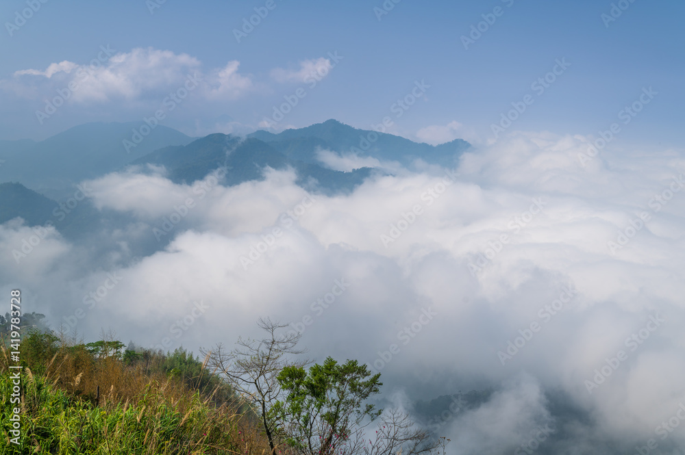 A serene view of the mist-covered mountains in Fanlu Township, Chiayi County, Taiwan, captured on a spring afternoon. The dense fog creates a mystical atmosphere, enveloping the lush green hills. A serene view of the mist-covered mountains in Fanlu Township, Chiayi County, Taiwan, captured on a spring afternoon. The dense fog creates a mystical atmosphere, enveloping the lush green hills.