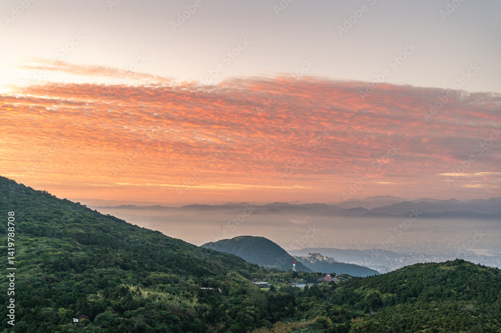 Obraz premium At Datun Mountain, dawn unfolds like an artist's canvas, as clouds shift hues from purple to gold, casting the city into a mystical haze.