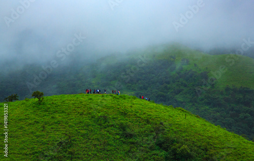 A group of toursits enjoying the view from top of a hill in Chikmagalur - on the way to Baba Budan Giri hills (Karnataka, India)