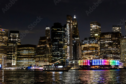 Obraz na płótnie Illuminated skyline of New York City at night showcasing colorful lights along the waterfront w salonie