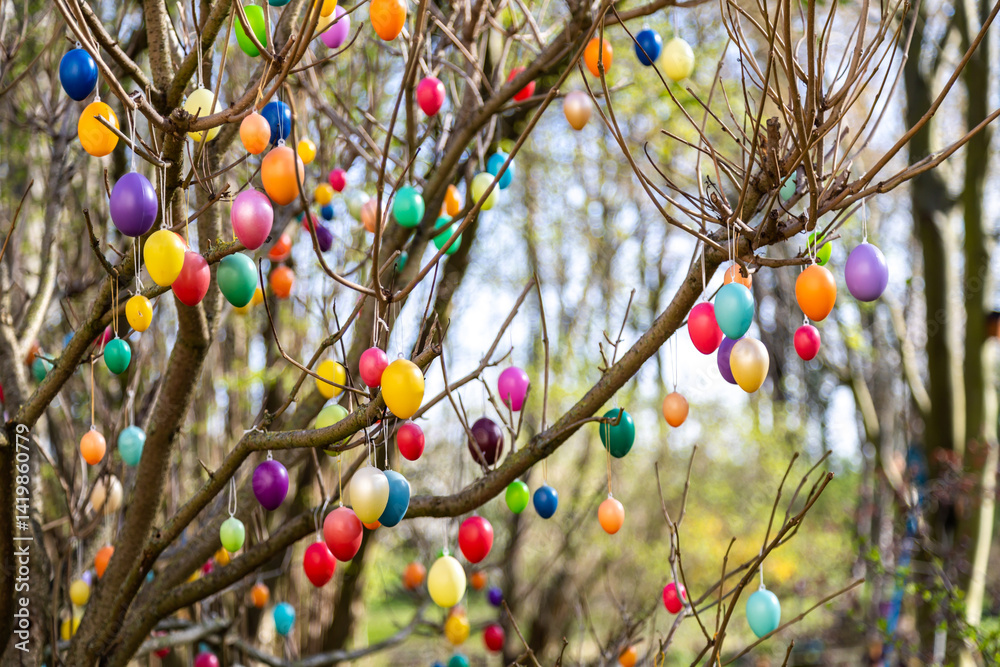 Viele bunte Eier hängen an einem Baum zu Ostern als Dekoration
