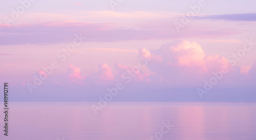 Serene Pink Sunset over Calm Ocean with Soft Cloudscape