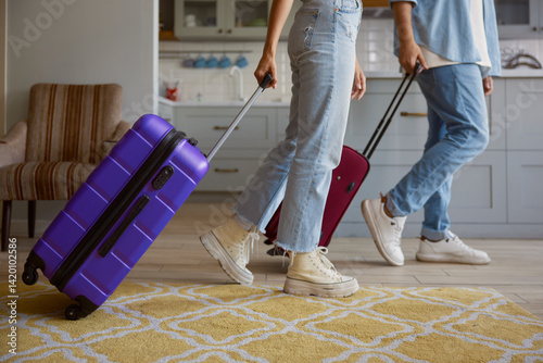 Obraz na płótnie Crop view of couple leaving home with luggage ready for vacation w salonie
