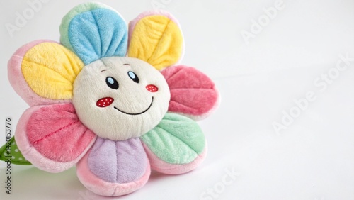 A close up of a colorful plush flower with a smiling face on a white surface in a studio shot created with generated ai