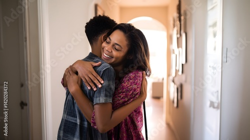 A heartwarming hug between a mother and son in a bright, inviting hallway. Emotional connection and love are palpable in the scene.