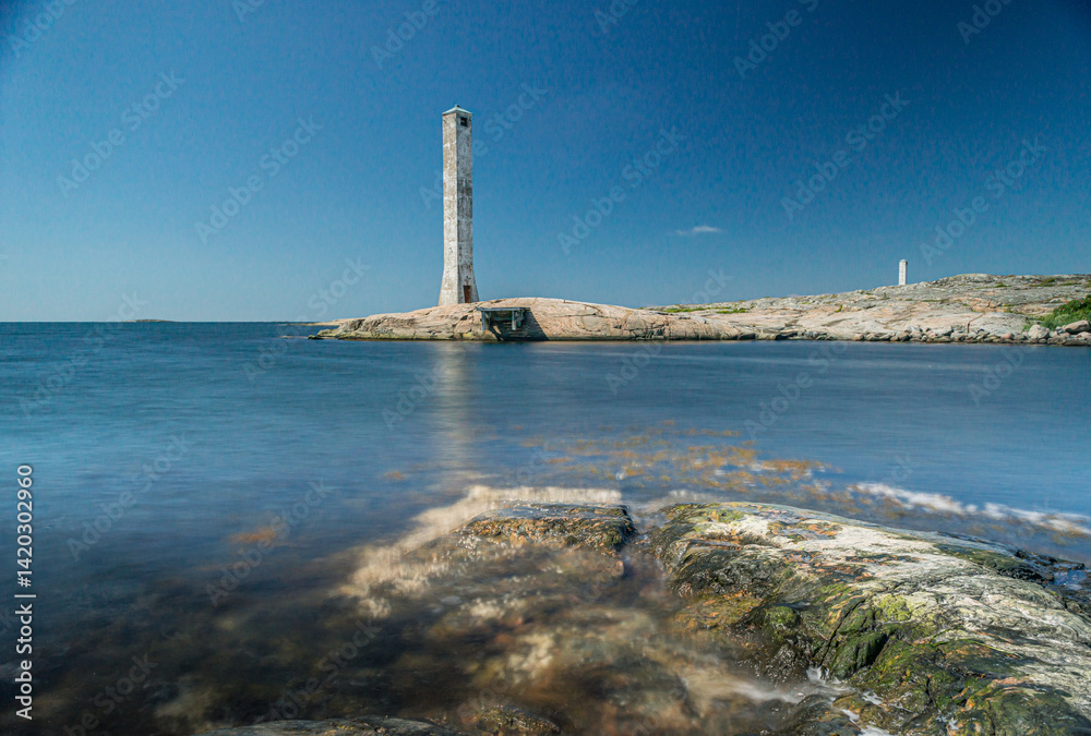 Lonely lighthouse by calm sea. Lonely lighthouse by calm sea.