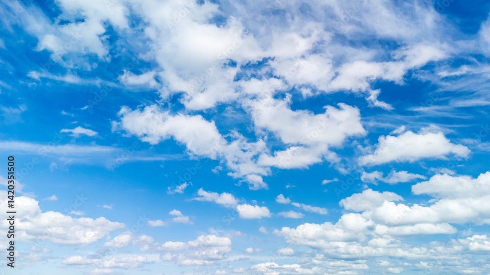 Fototapeta premium Bright blue sky filled with white fluffy clouds, creating a serene and uplifting atmosphere suitable for various projects, including nature themes and backgrounds.