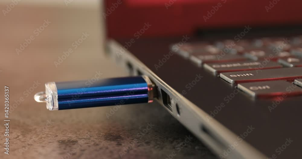 Man inserting modern flash drive at grey table, closeup
